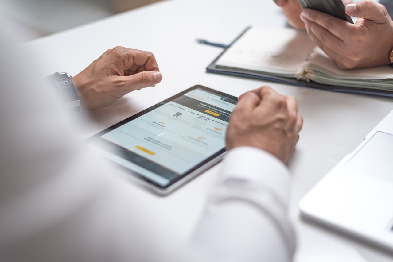 Mastering the First Impression: Your intriguing post title goes here Close-up of professionals using a digital tablet and smartphone during a meeting.